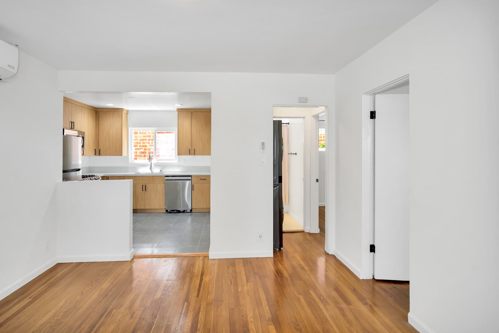 Renovated open living area and kitchen with hardwood floors